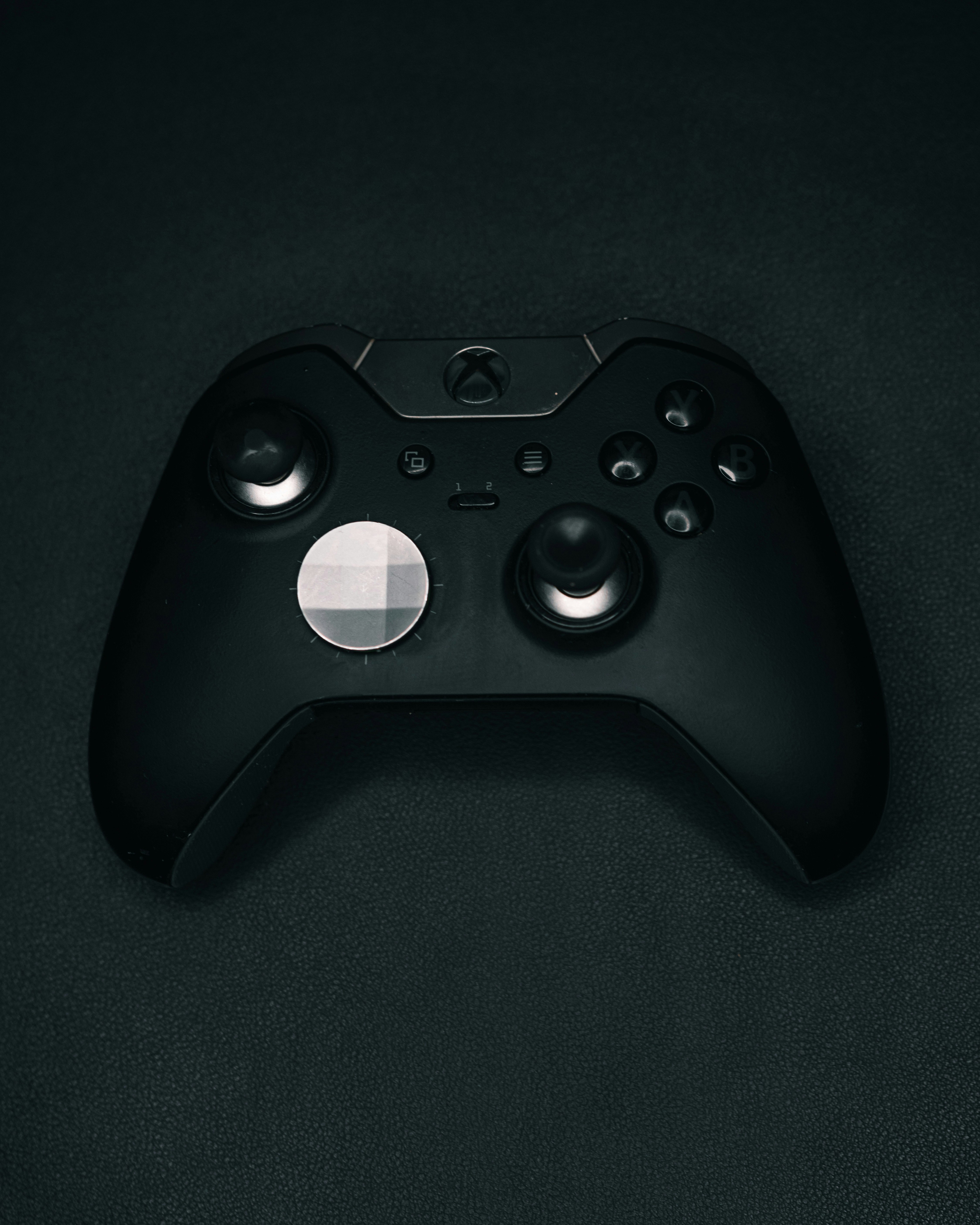 a close up of a black controller on a black surface