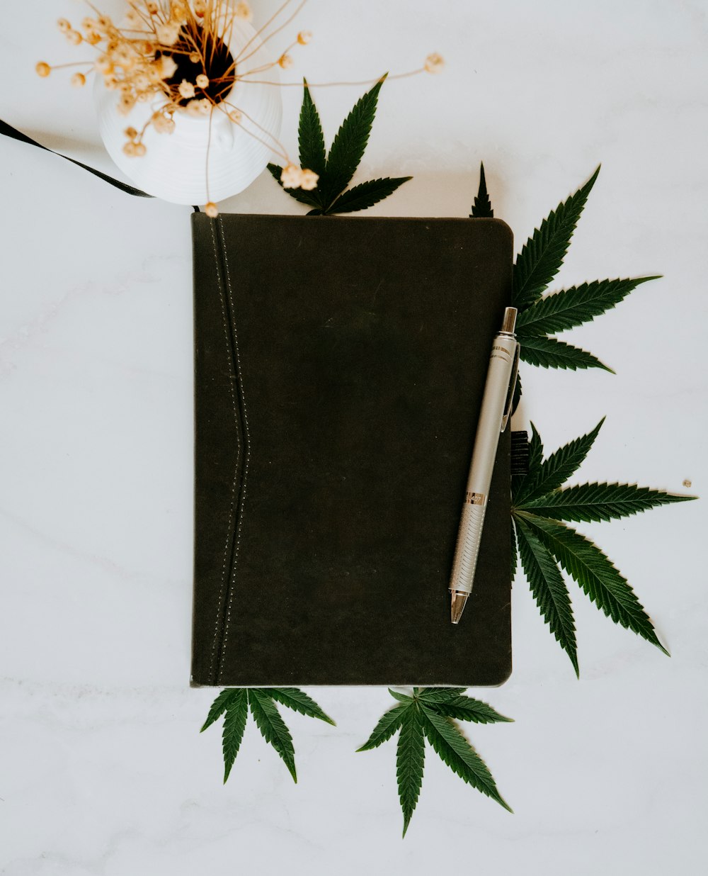 a notebook with a marijuana leaf on top of it