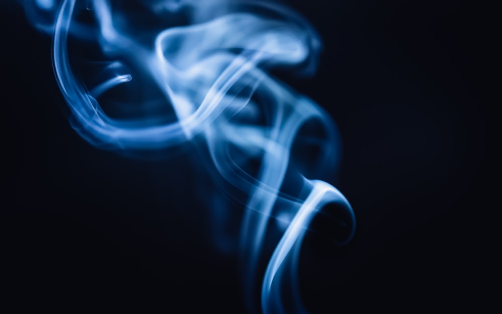 une photo floue de fumée bleue sur fond noir
