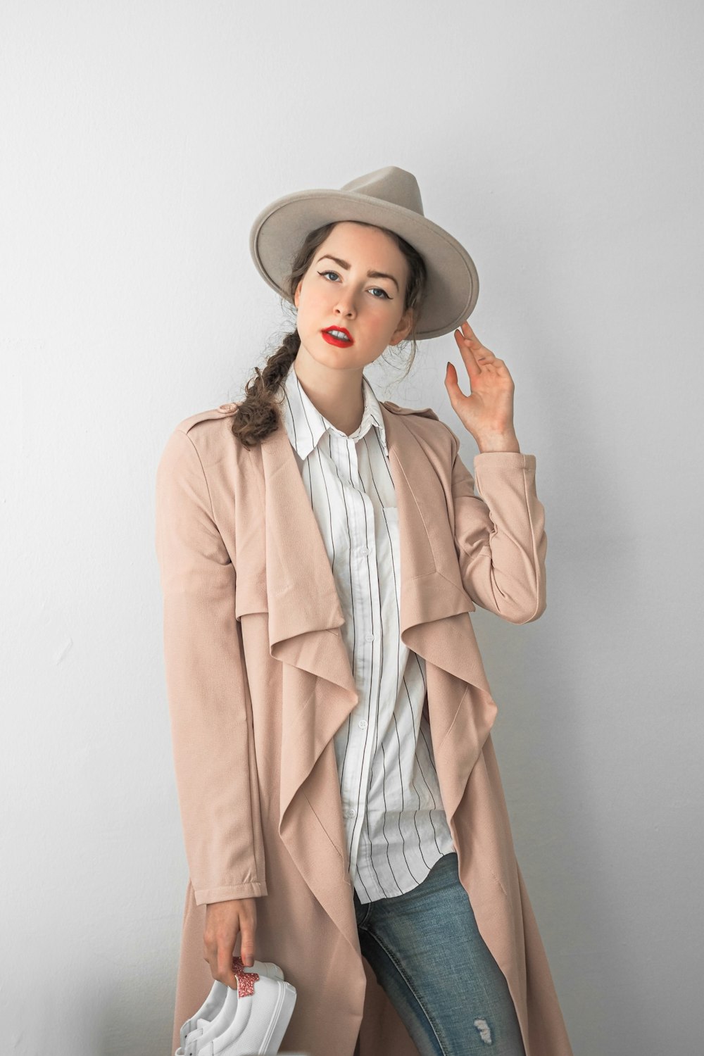 a woman in a hat and coat posing for a picture