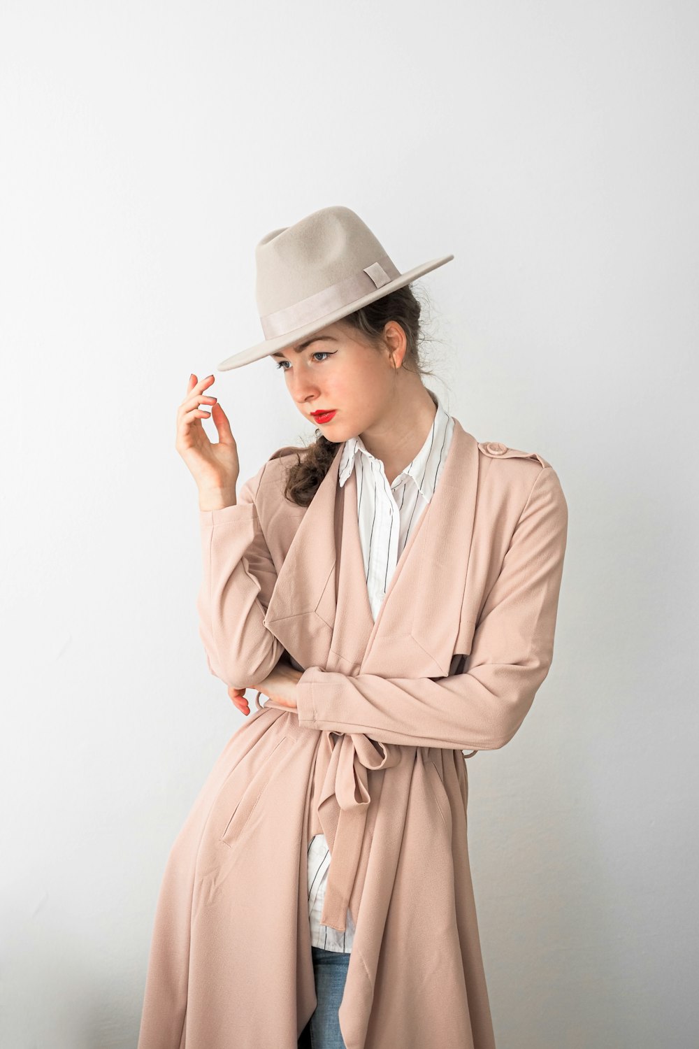 a woman in a trench coat smoking a cigarette