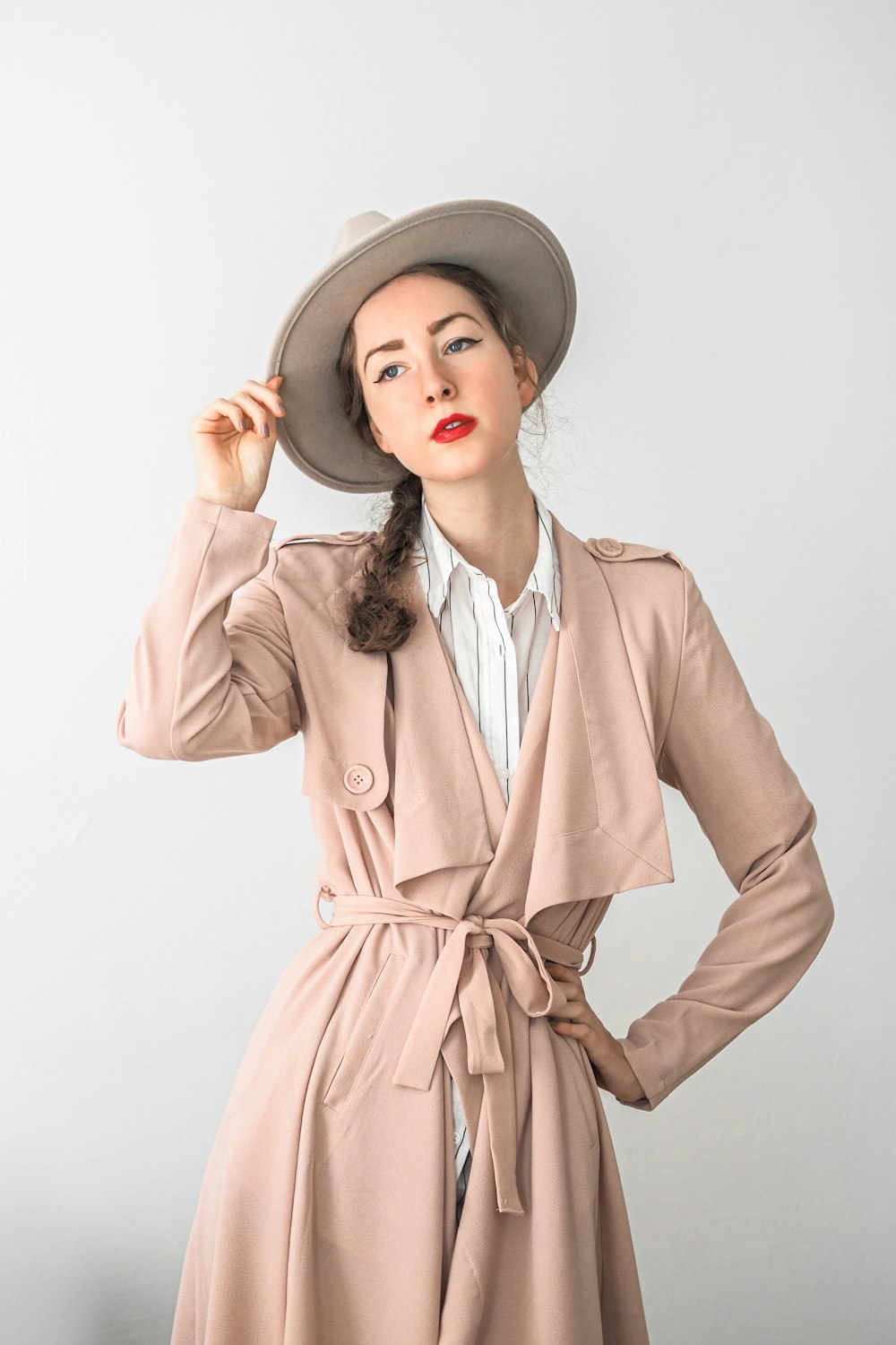 a woman wearing a trench coat and hat