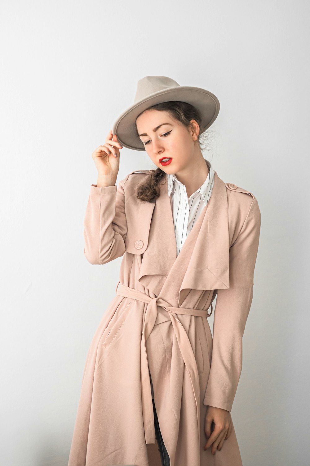 a woman wearing a trench coat and hat