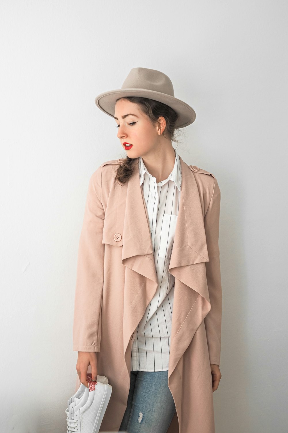 a woman in a hat and trench coat