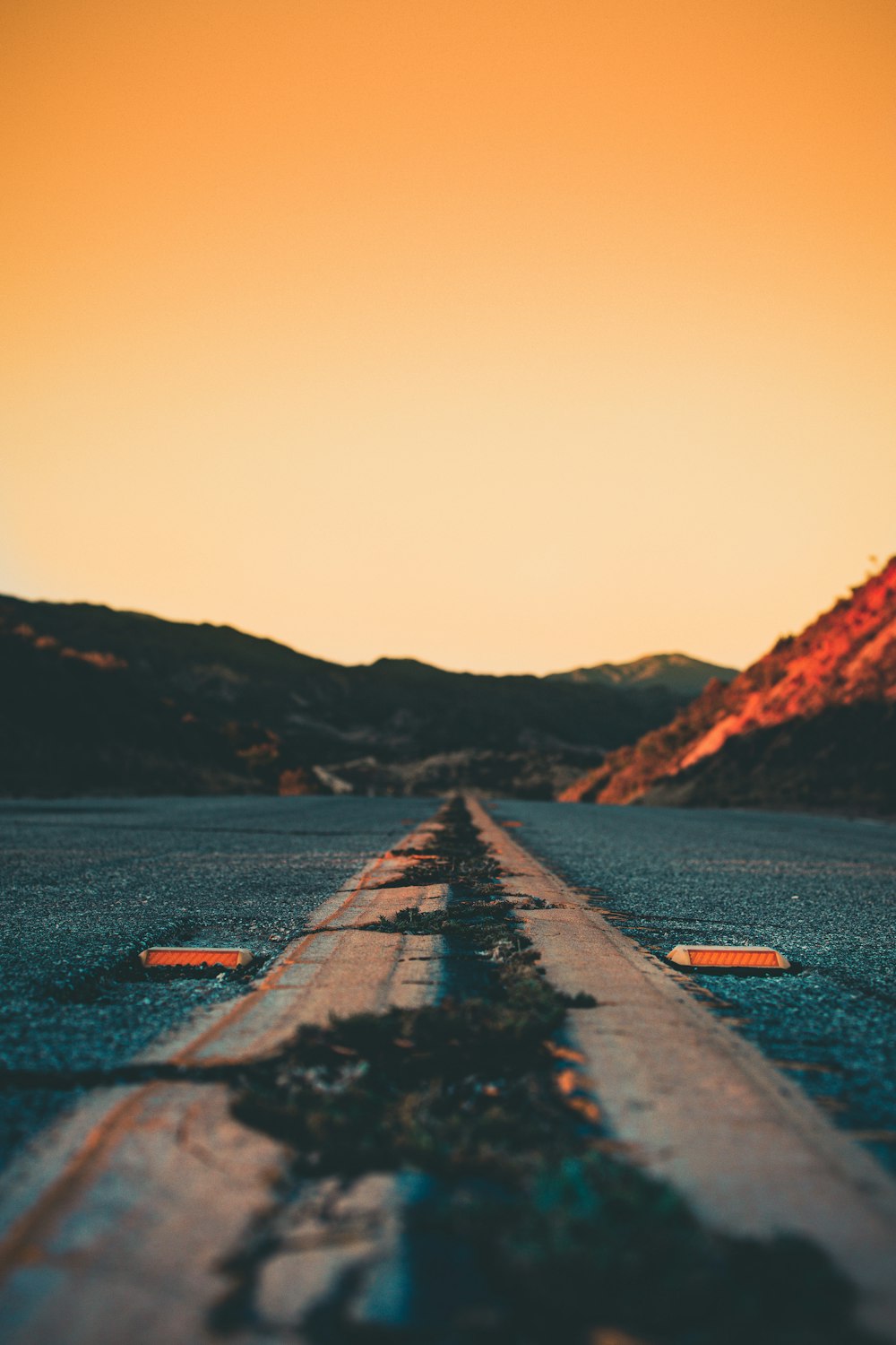 an empty road with mountains in the background