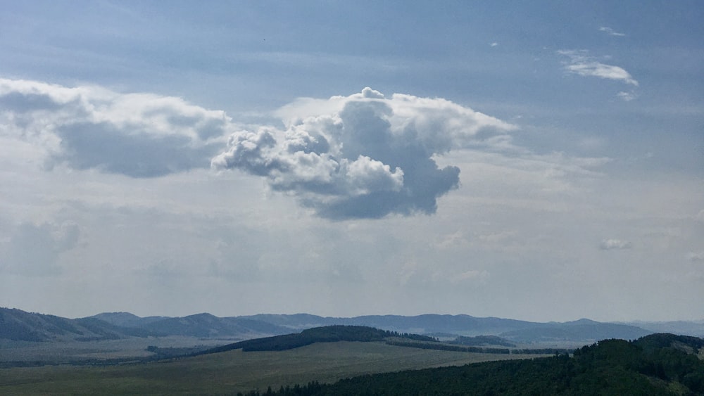 a view of a mountain range with a cloud in the sky