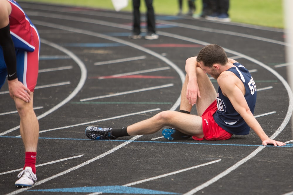 a man sitting on the ground in a track