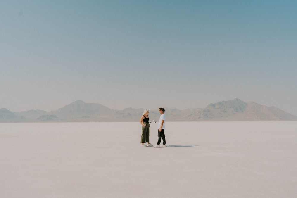 two people standing in the middle of a desert
