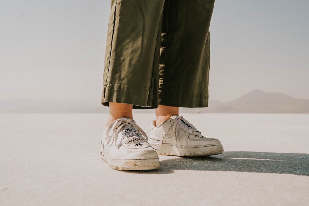 a person's legs and shoes in the desert