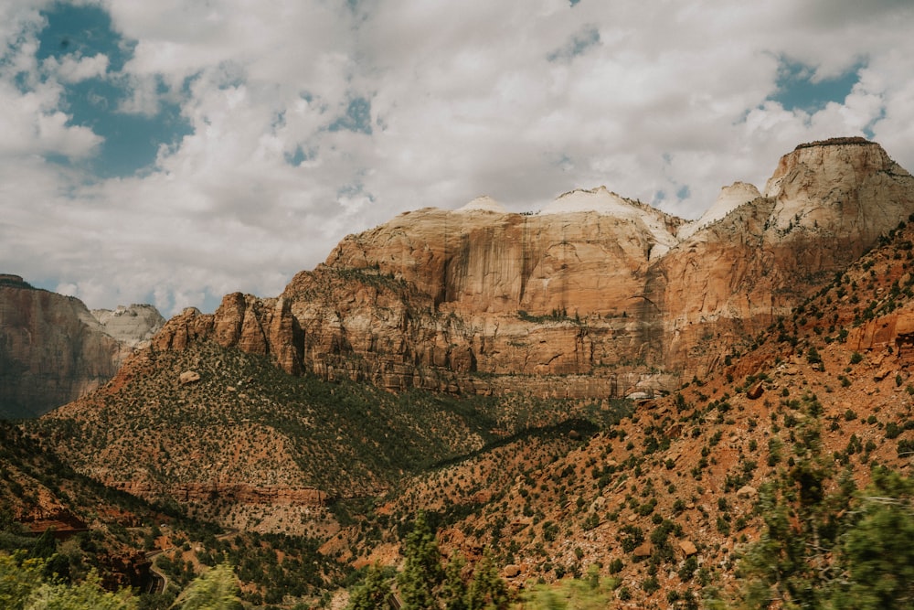 a scenic view of mountains and trees under a cloudy sky