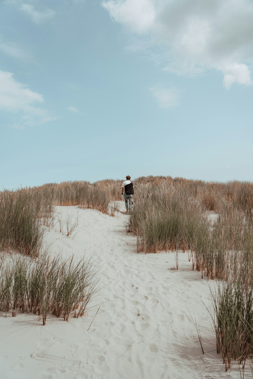 a man riding a bike on top of a sandy beach