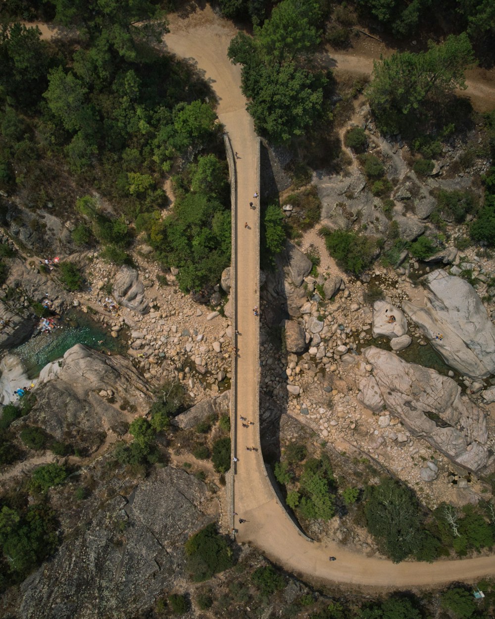 an aerial view of a road surrounded by rocks and trees