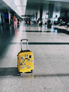 a yellow piece of luggage sitting on top of a floor