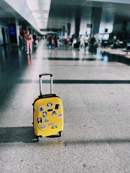 a yellow piece of luggage sitting on top of a floor