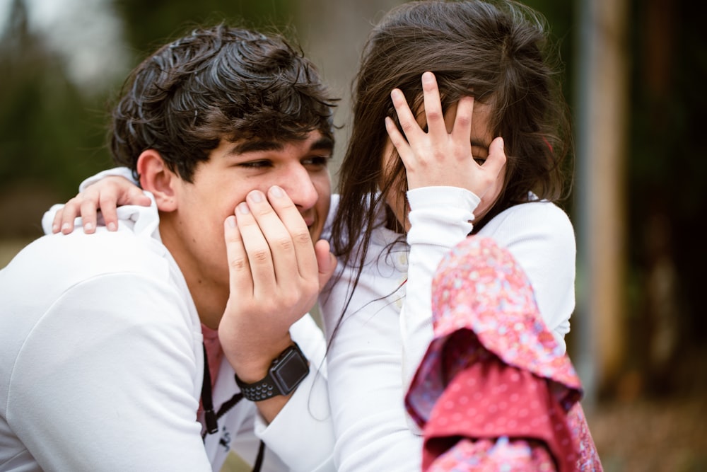 a man and a woman covering their faces