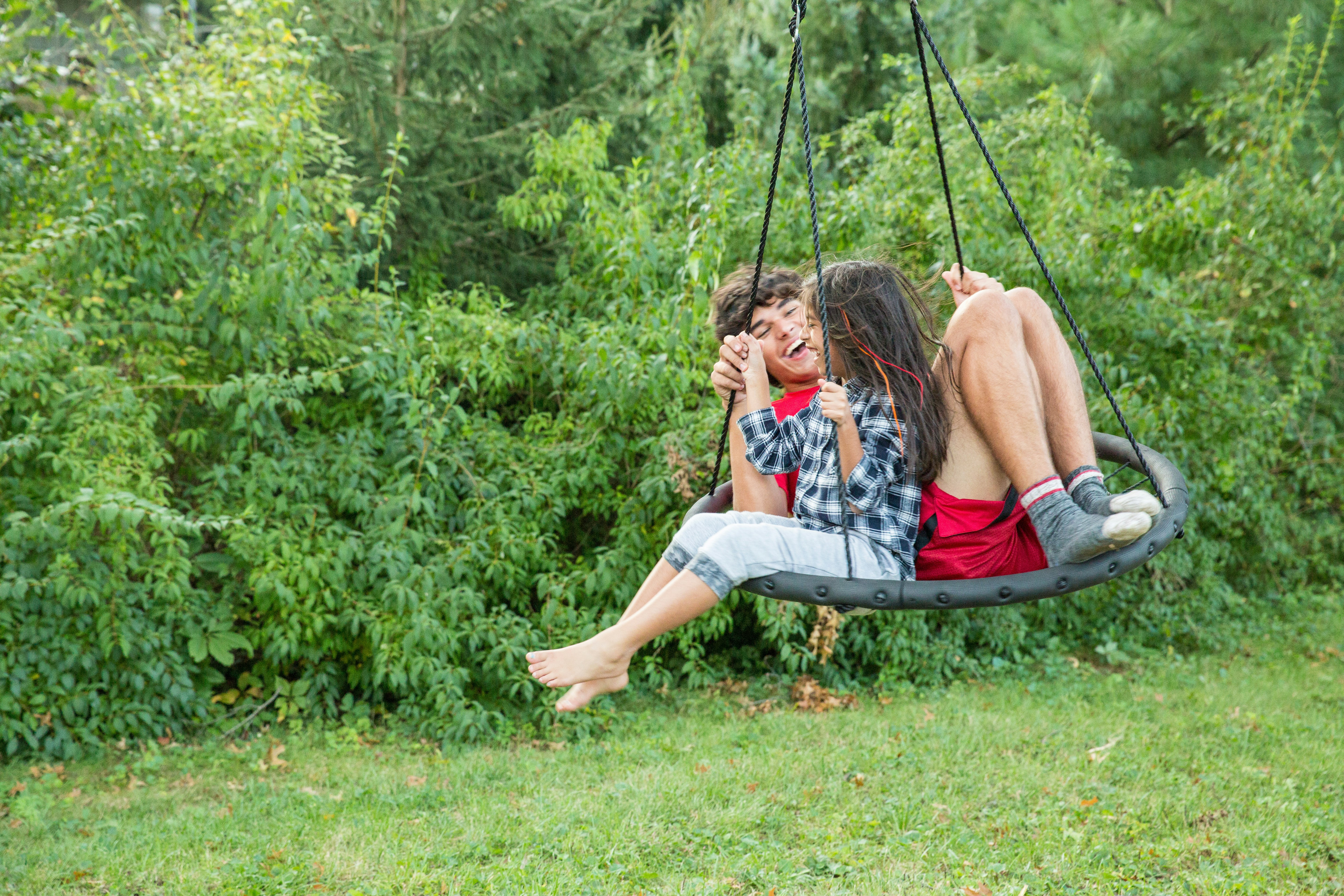 a man and a woman sitting on a swing
