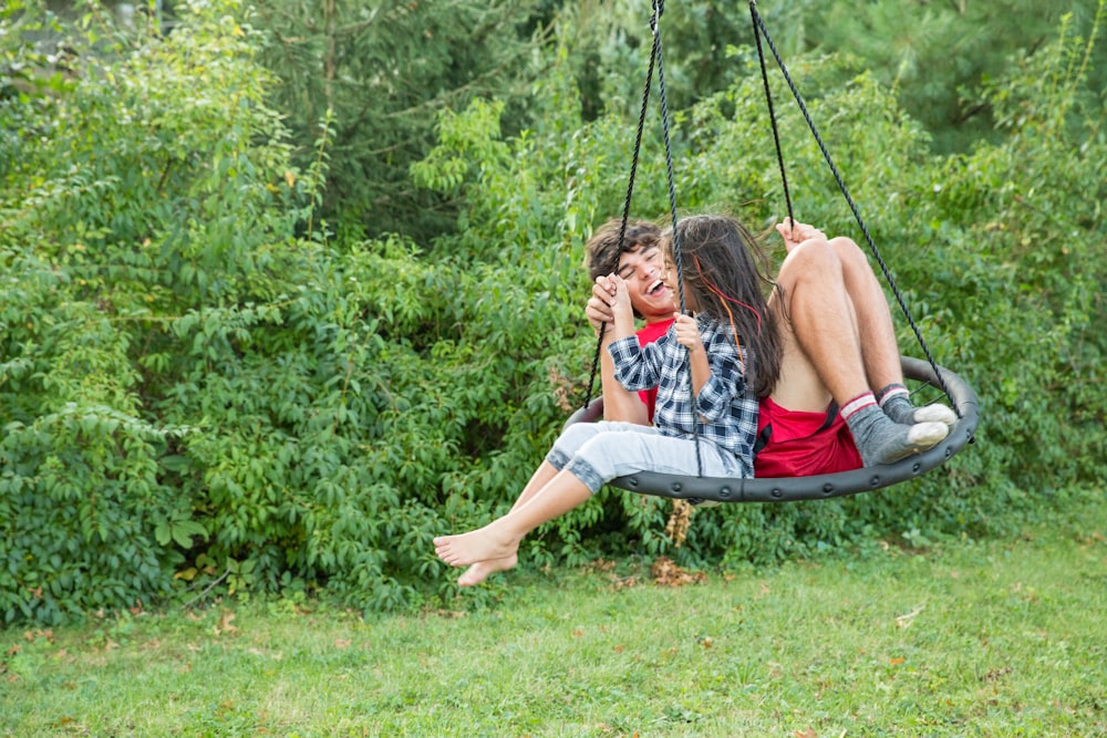 a man and a woman sitting on a swing