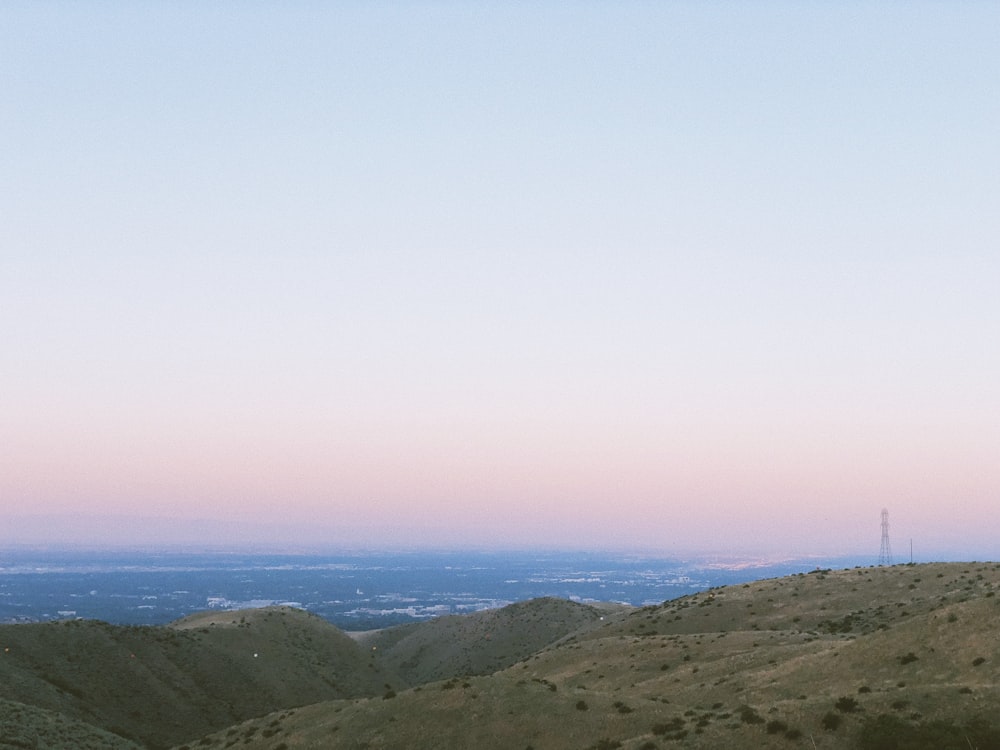 a view of a hill with a cell phone tower in the distance