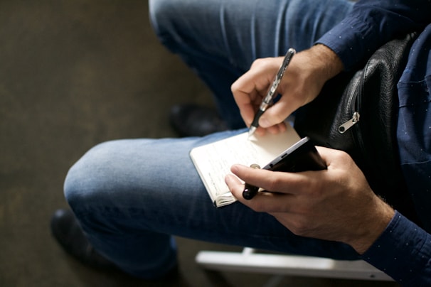 a man sitting on a chair using a cell phone