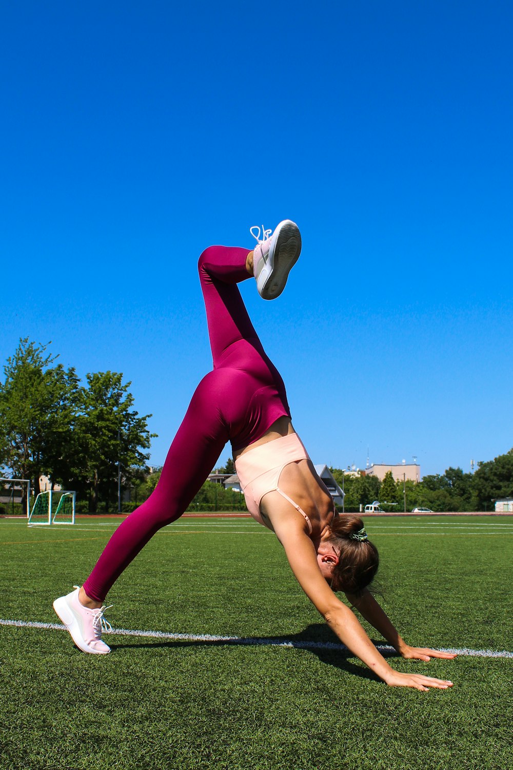a woman doing a handstand on a soccer field