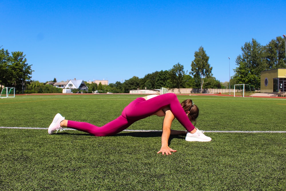 a woman is doing a plank on a soccer field