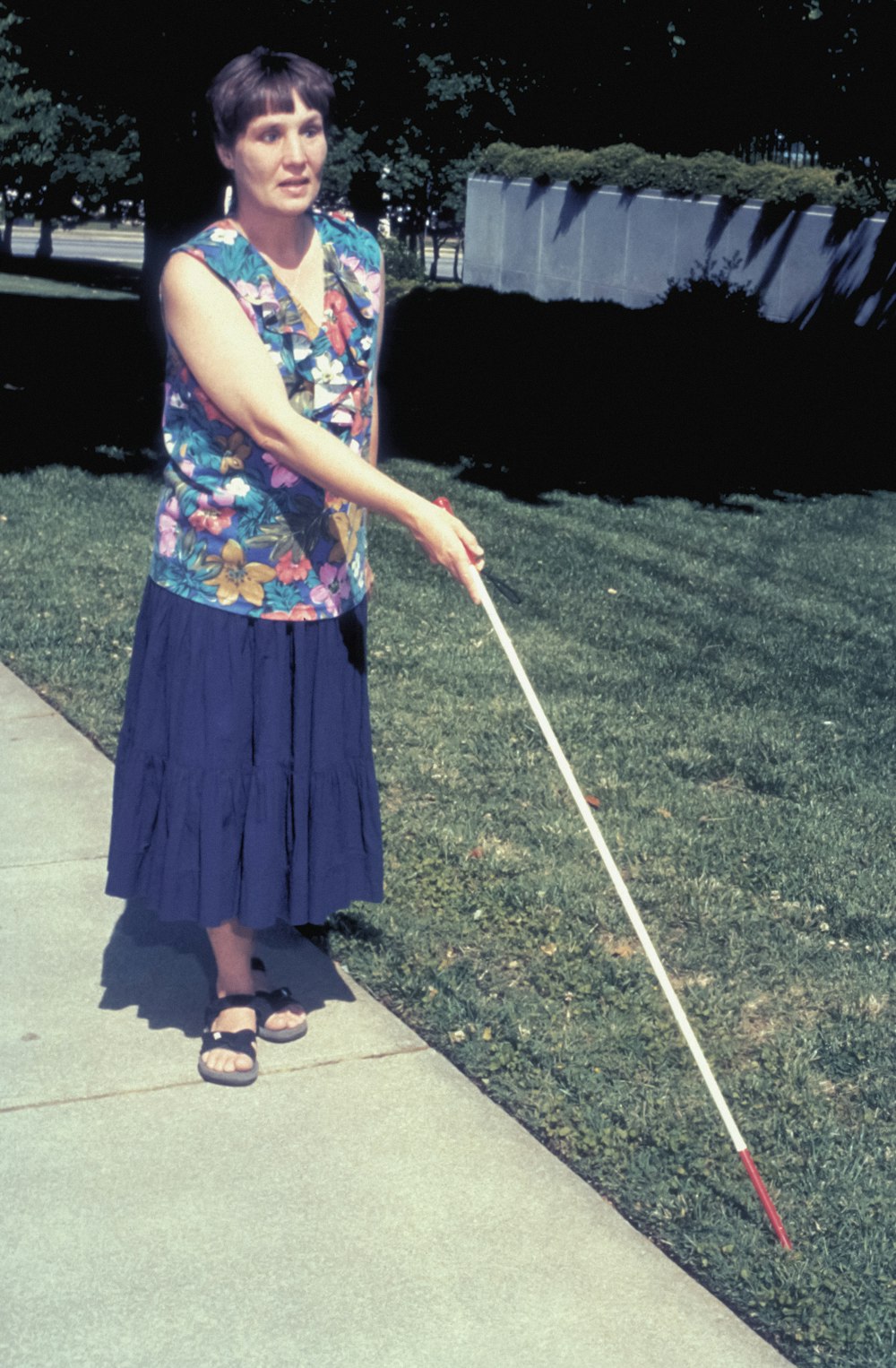 a woman holding a golf club on a sidewalk