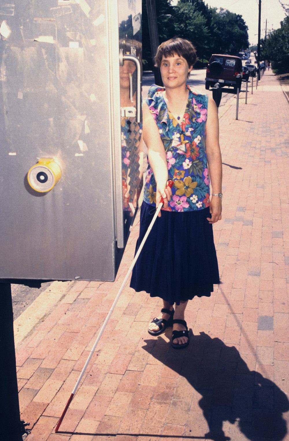 a woman standing next to a bus on a sidewalk
