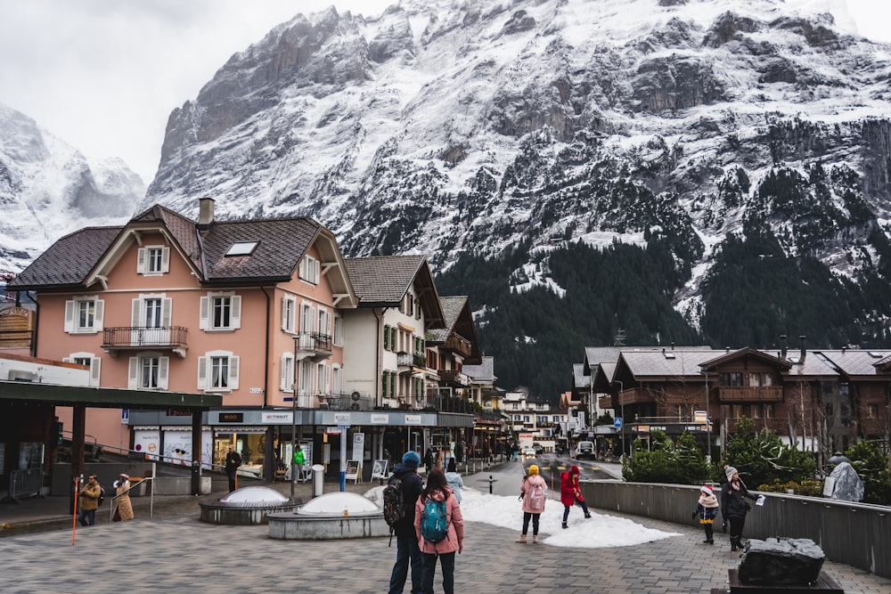 a group of people standing in front of a snow covered mountain