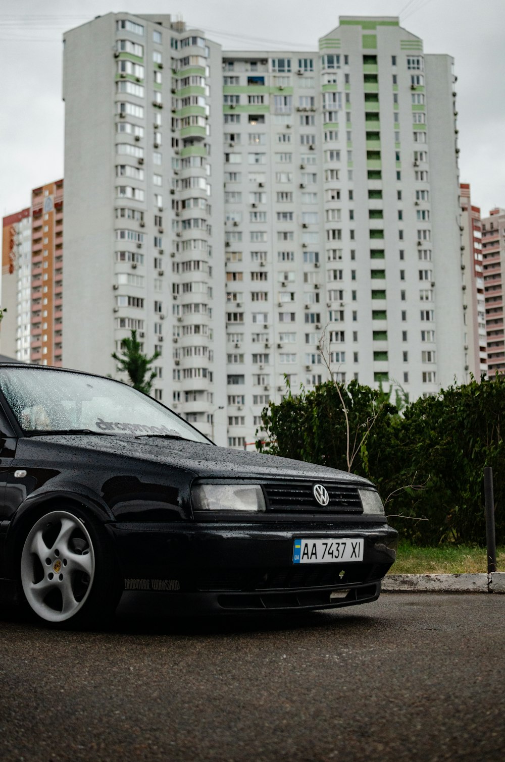 a black car parked in front of a tall building