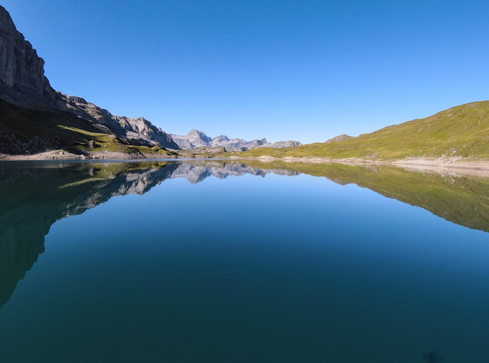 a body of water with mountains in the background