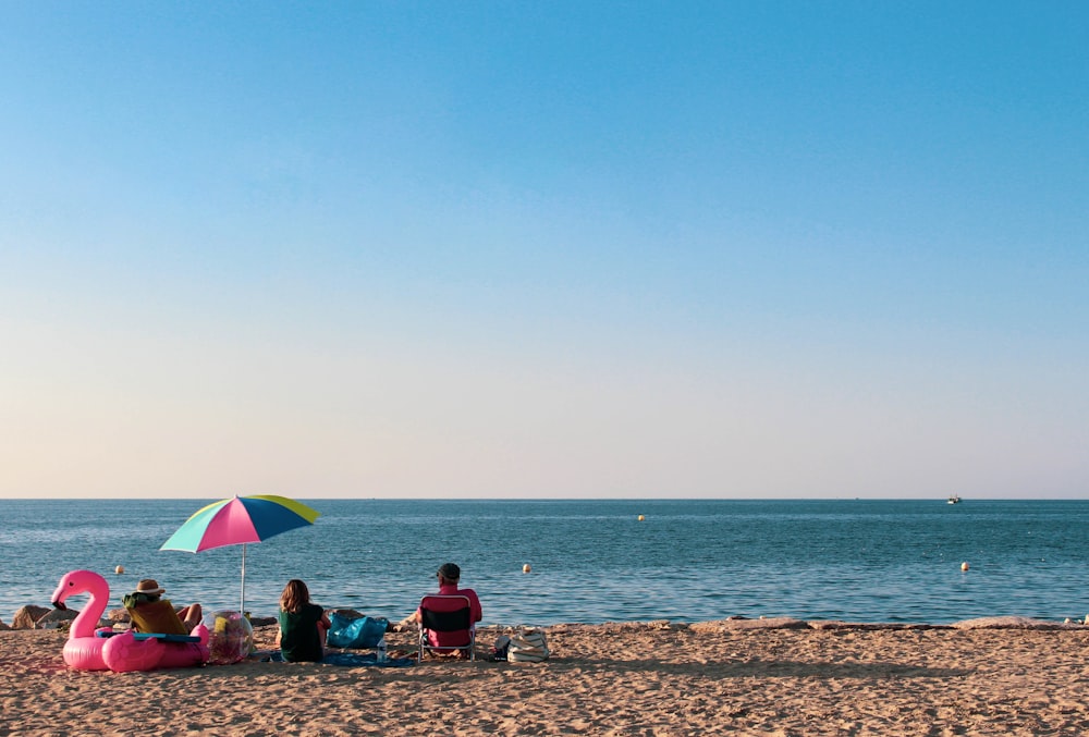 um grupo de pessoas sentadas em cima de uma praia de areia