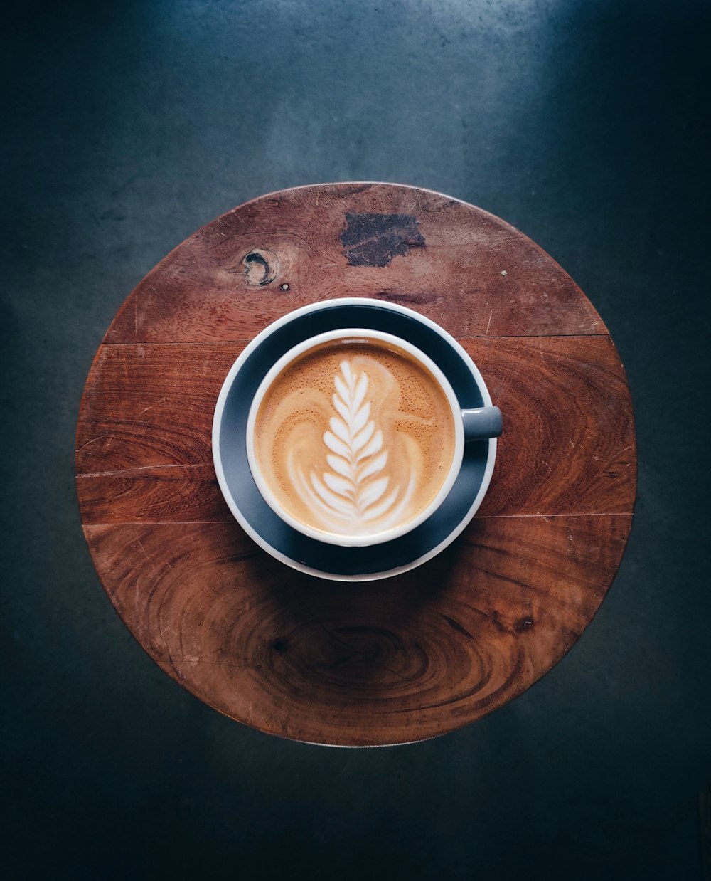 a cup of coffee on a wooden table