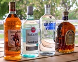 three bottles of alcohol sitting on top of a wooden table