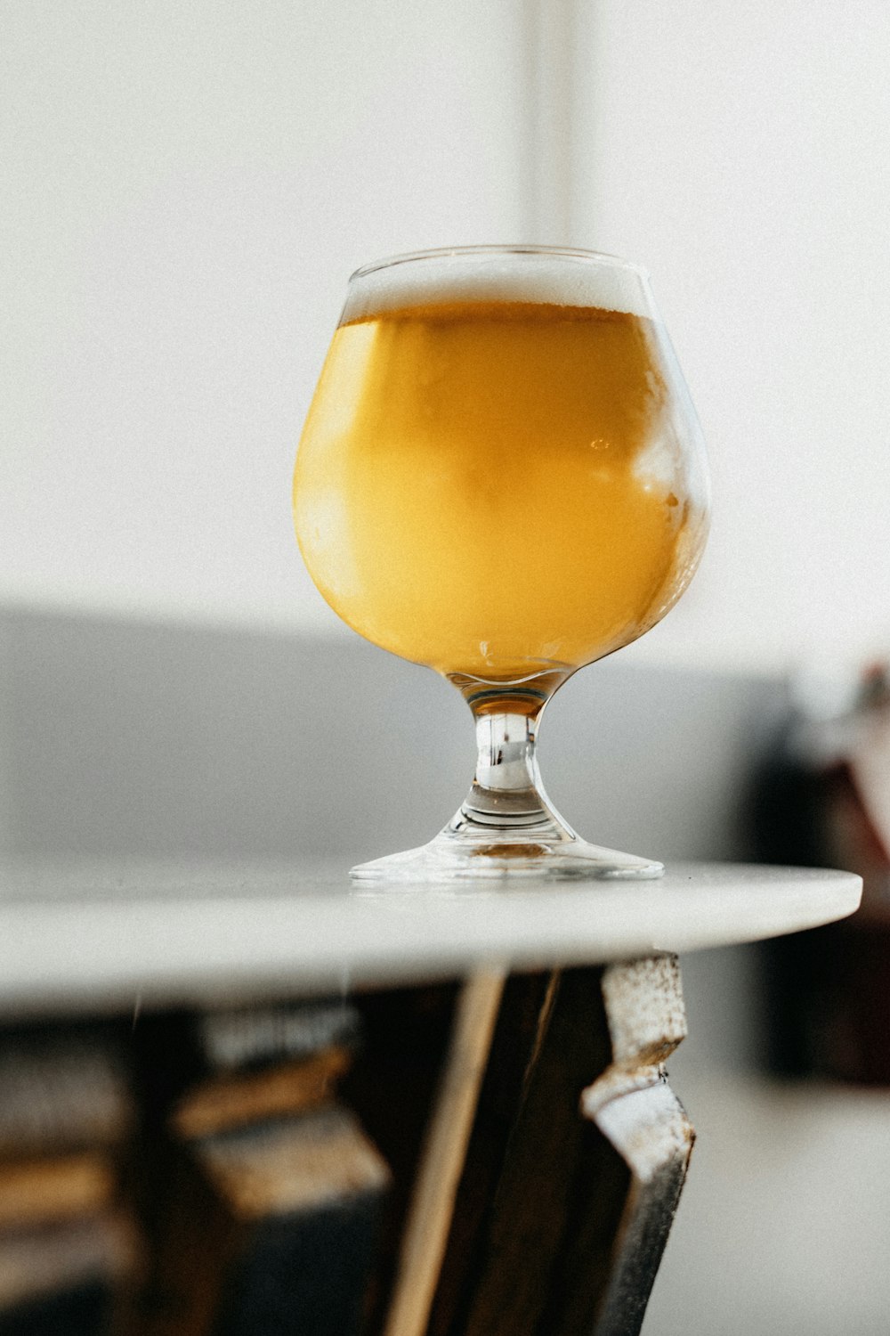 a glass of beer sitting on top of a table