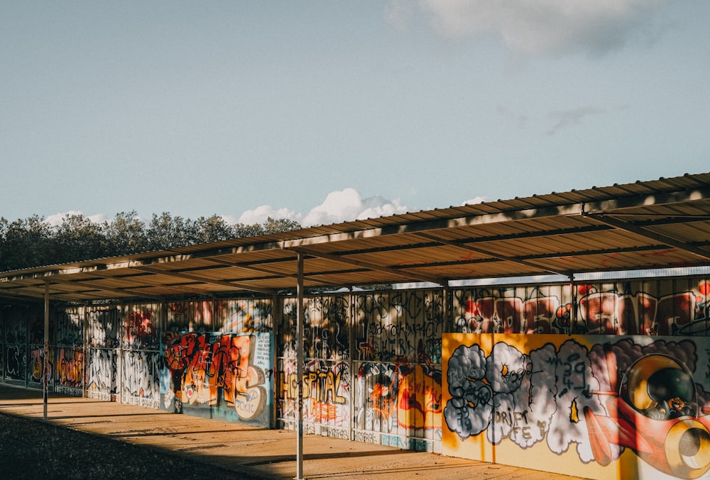 a bus stop covered in graffiti under a blue sky