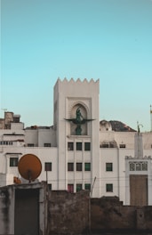 a tall white building with a clock on it's face