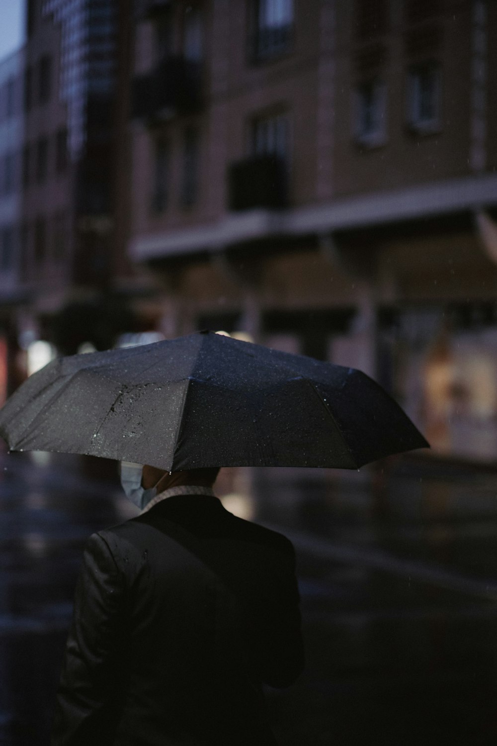 a man walking down a street holding an umbrella