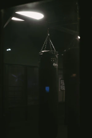 a black boxing bag in a dark room