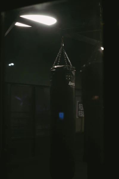 a black boxing bag in a dark room