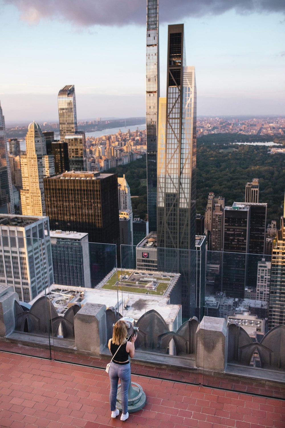 a woman taking a picture of a cityscape