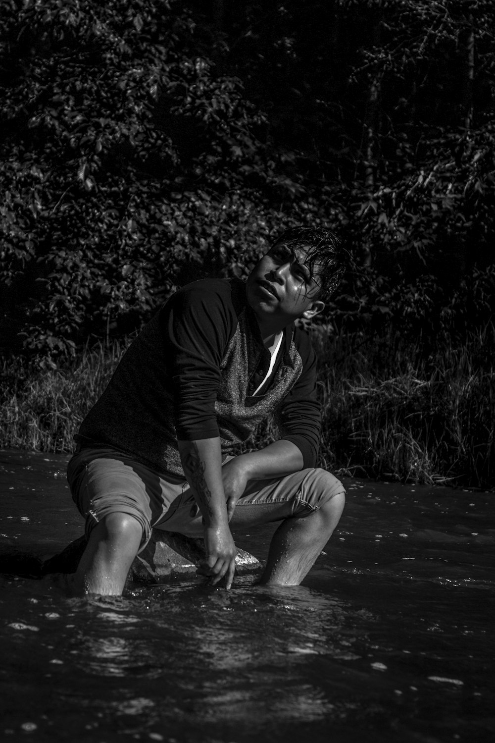 a man kneeling down in a body of water