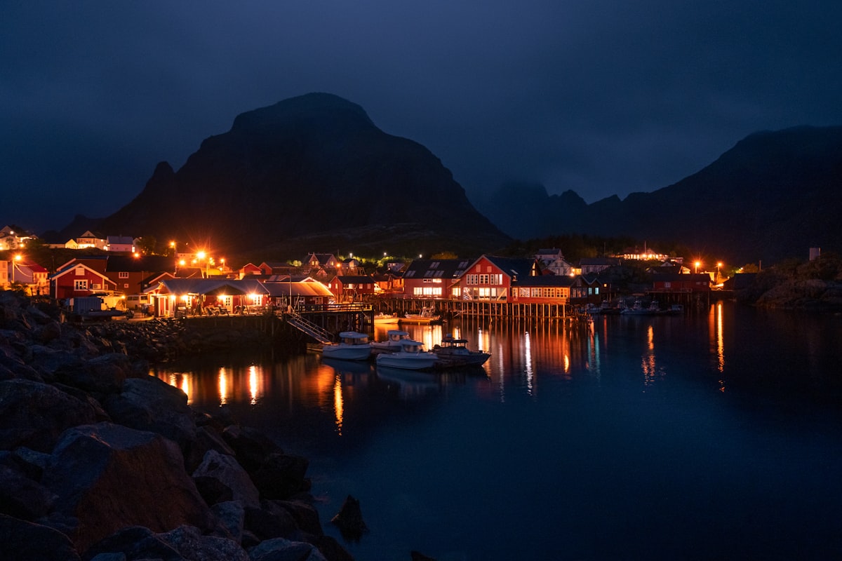 Lofoten December — polar night blue twilight over Reine with snow-capped peaks