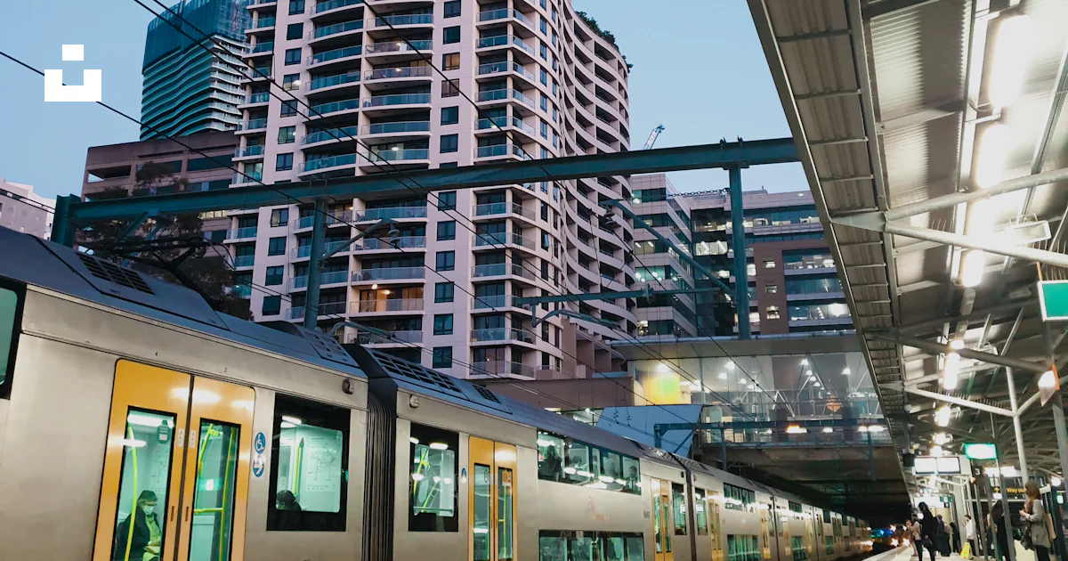 Train Rests On Building A train pulling into a train station next to a tall building photo ...