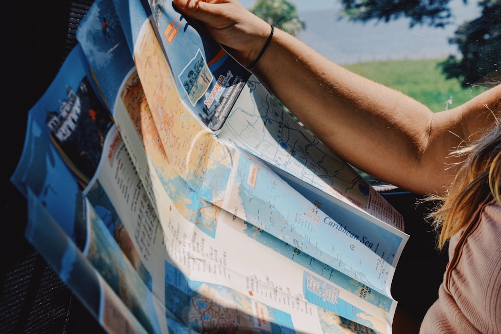 a woman is holding up a large newspaper