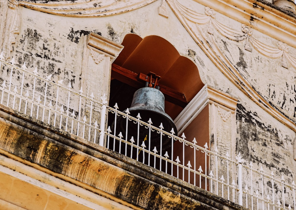 a large bell sitting on the side of a building