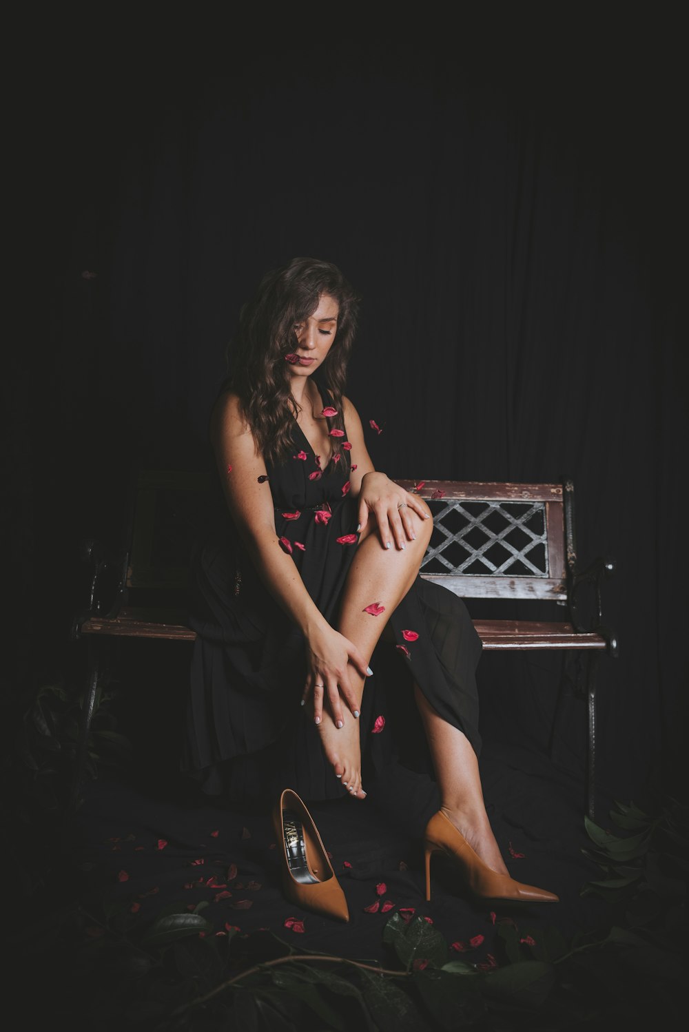 a woman sitting on a bench with her legs crossed