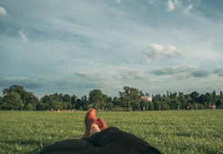 a person laying in the grass with their feet up