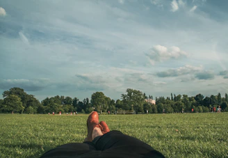 a person laying in the grass with their feet up
