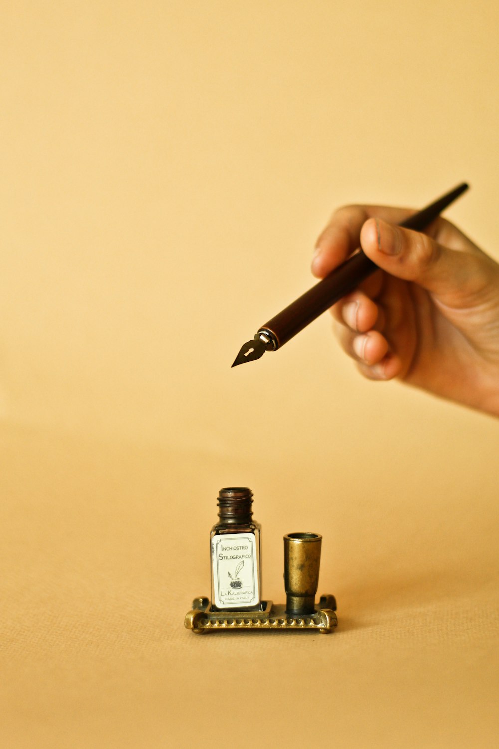 a person holding a pen and writing on a piece of paper