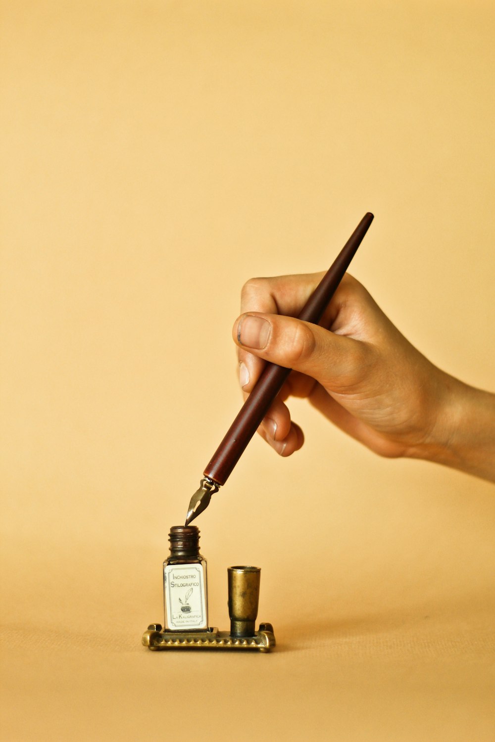 une main tenant un stylo et écrivant sur une bouteille